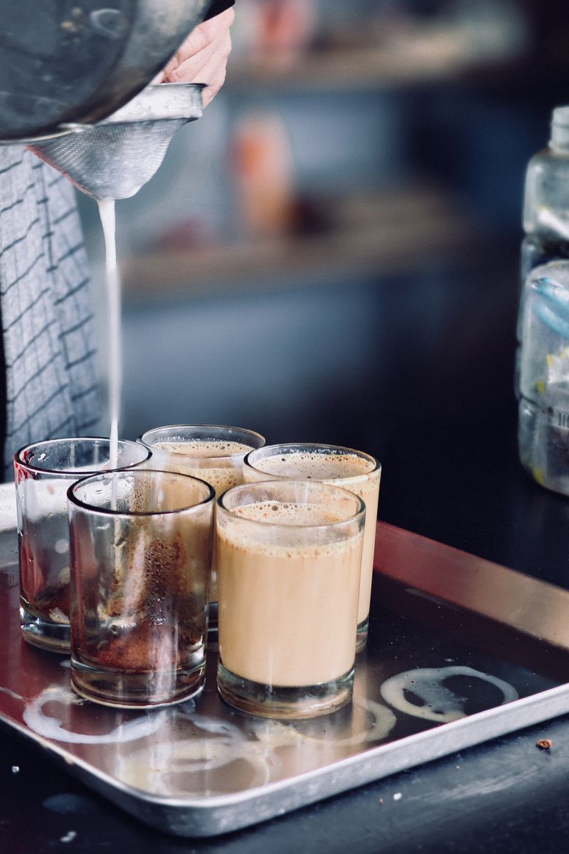Chai being poured from a height into a clay cup